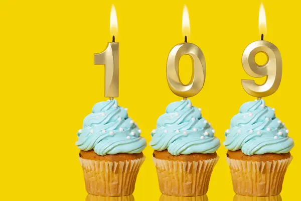 stock image Birthday Cupcakes With Candles Lit Forming The Number 109 - Photo On Yellow Background.