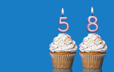 Doğum günü Kekleri ve Mumlar Mavi Arkaplanda 58 Numarayı oluşturuyor.