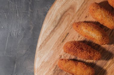 Tipik İspanyol kroketleri yemeye hazır. Tahta ve siyah arka planda ev yapımı İspanyol kroketleri. Tapas yemeği. Kara yemek..