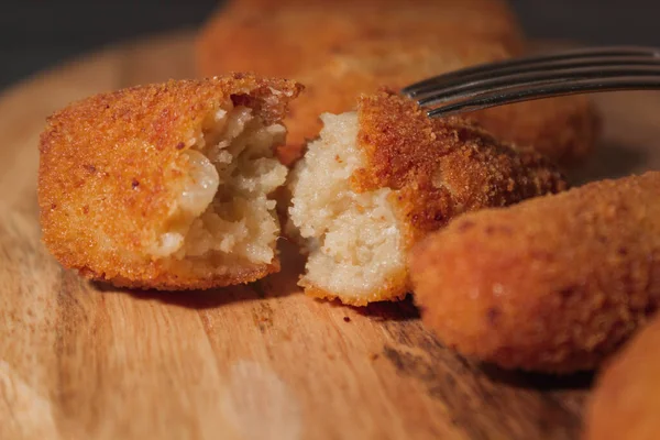 Tipik İspanyol kroketlerini yakın çekim. Tahta ve siyah arka planda ev yapımı İspanyol kroketleri. Tapas yemeği. Kara yemek..