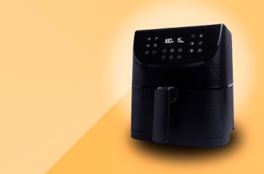 Air Fryer, fotokopi alanı olan açık turuncu arkaplanda izole edildi. Sağlıklı yiyecekler için küçük ev aletleri.