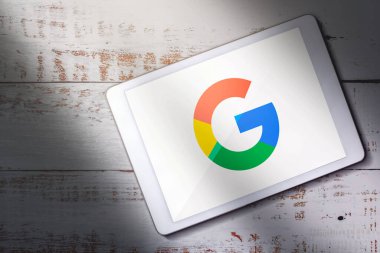 MLAGA - SPAIN - DECEMBER 21, 2022: Top view of digital tablet with Google logo on screen. Wireless tablet technology with intelligence search engine.