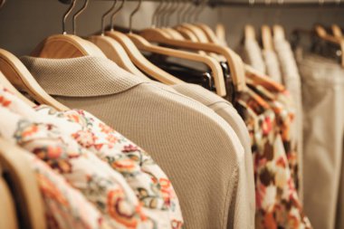 Modern bir butik mağazasında askılarda renkli kıyafetler..