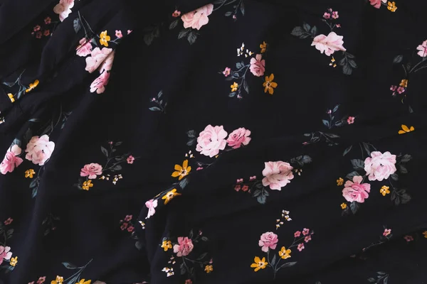 Dark flower cloth pattern for background and with copy space. Beautiful floral design on dark blouse textured. Vintage design. Close up photo.