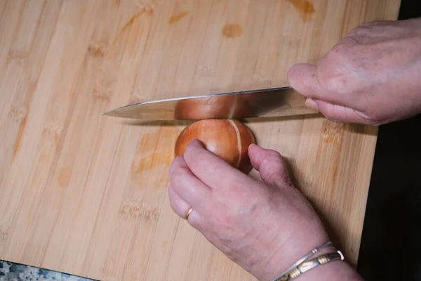 用手把新鲜的洋葱切碎在厨房的木板上 烹调健康食品 — 图库照片