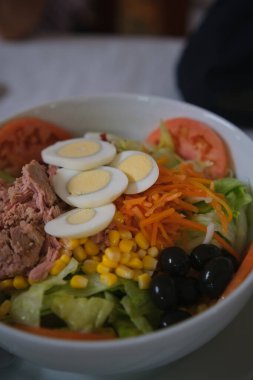 Lezzetli ve taze karışık salata ton balığı, domates, haşlanmış yumurta, marul, tatlı mısır rendelenmiş havuç ve siyah zeytin..