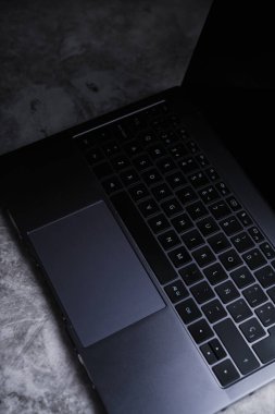 Modern masanın arkaplan görüntüsü dizüstü bilgisayara ve kasvetli gölgelere odaklı. Metin için boş alanı olan işyeri.