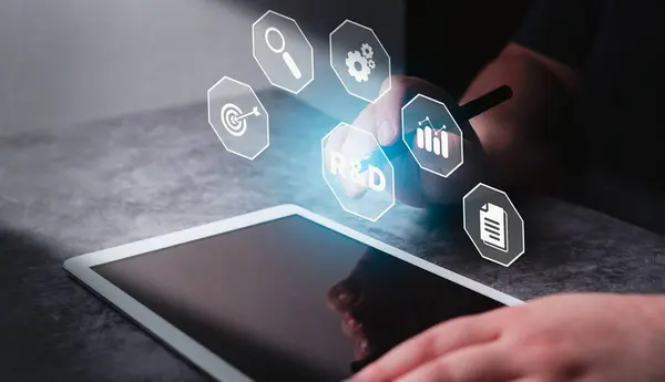 Kadın, Araştırma ve Geliştirme 'nin sanal arayüzünü gösteren dijital tablet kullanıyor. Yeni ürün geliştirme sürecini yeniden mayınlamak ve piyasaya yeni ürünler çıkarmak için Ar-Ge.