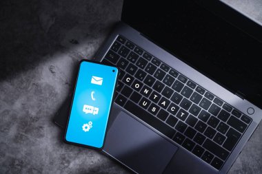 Ekran adresi, telefon, e-posta ve çağrı simgelerinde müşteri desteği için akıllı telefonun üst görünümü. Posta sitelerinden, iş irtibat hizmetinin dijital teknolojisinden yardım.