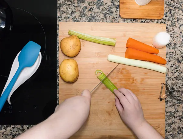 Şeflerin ellerinin sebzeleri hazırlayıp doğradığı en iyi manzara. Mutfak manzarası. İçinde malzemeler olan yemek tarifi. Ev yapımı tabak..