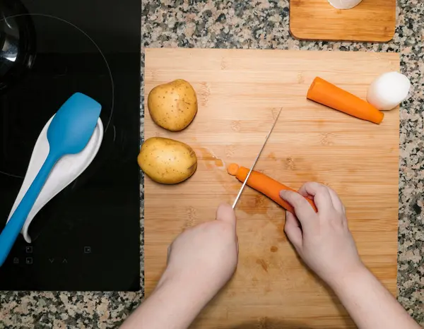 Şeflerin ellerinin sebzeleri hazırlayıp doğradığı en iyi manzara. Mutfak manzarası. İçinde malzemeler olan yemek tarifi. Ev yapımı tabak..