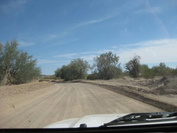 在亚利桑那州的一条宽阔平坦的泥泞路上开车 高质量的照片 — 图库照片