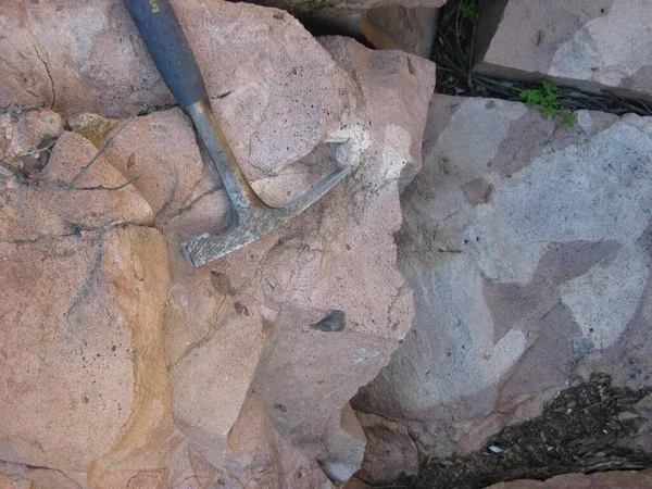 Geology Rock Hammer Laying on Rocks for Scale. High quality photo