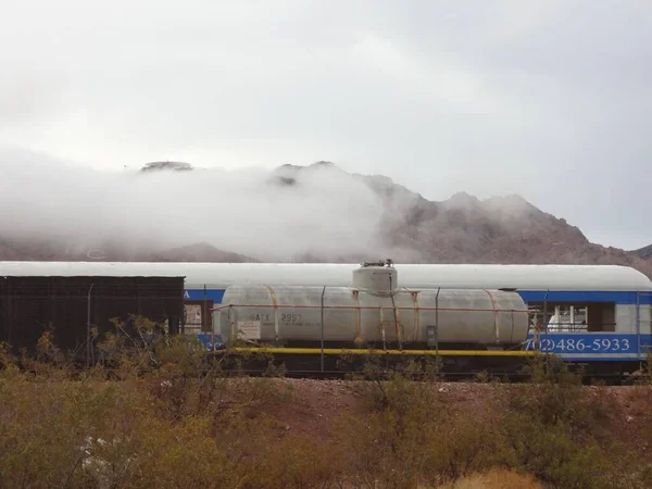 Old Rail Cars in Fog Clouds, Misty Desert Landscape . High quality photo