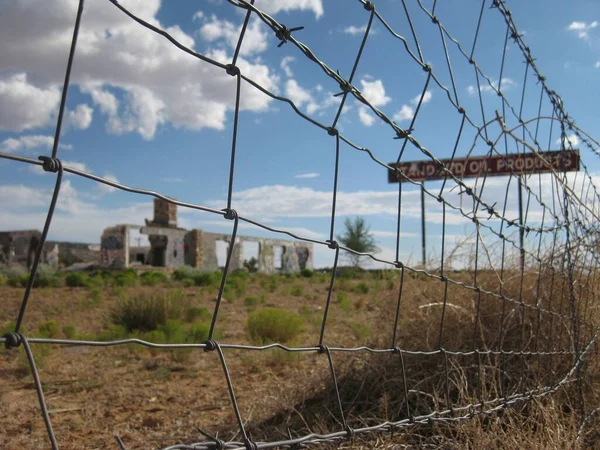 Abandoned Oil Building Behind Barbed Wire Fence in Arizona. High quality photo