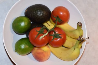 Çeşit çeşit domatesli meyve kasesi, muz, limon, avokado ve şeftali. Yüksek kalite fotoğraf