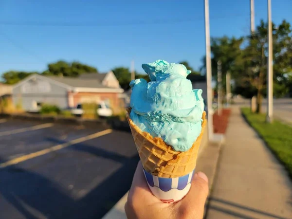 stock image Hand Holding Blue Moon Flavor Ice Cream Cone in Burlington, Wisconsin. Walking down the sidewalk eating food from local custard shop. High quality photo