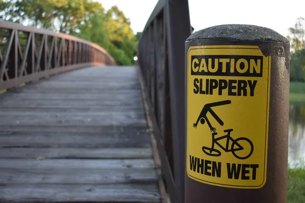 Внимание Скользко Мокрый Предупреждающий Знак Установлен Пустом Мосту Через Реку — стоковое фото