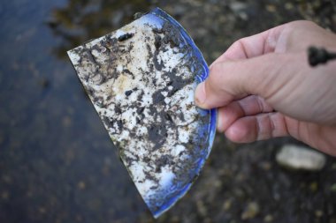 Fox River, Burlington, Wisconsin 'deki Kırık Çin Platosu' nun Kirli Parçalarını Tutan Parmaklar. Yüksek kalite fotoğraf