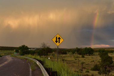 Lane Birleştirme İşareti ve Gökkuşağı ve Fırtına Holbrook, Arizona yakınlarında sürüyor. Yüksek kalite fotoğraf