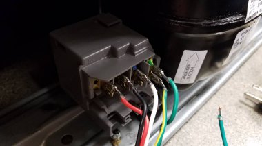 Küçük bir buzdolabının elektrik kablolarının elektrik kablolarını değiştiriyorum. Yüksek kalite fotoğraf