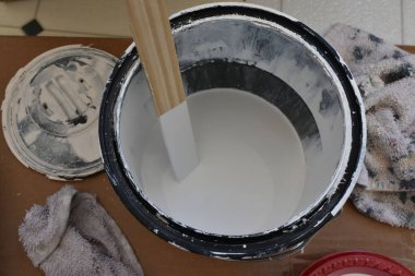 Tahta karıştırma çubuğuyla bir kutu boya, yarı beyaz renk. Yüksek kalite fotoğraf