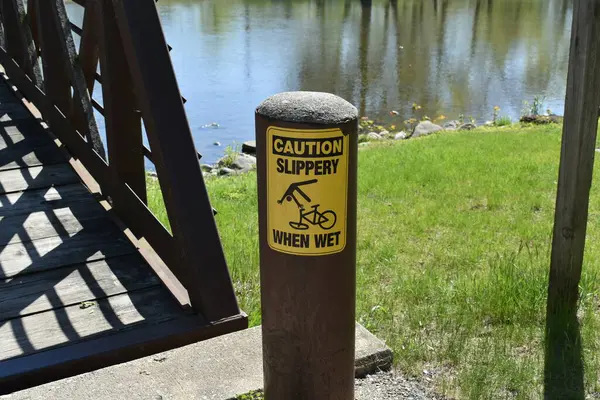 Burlington, Wisconsin 'deki Fox River üzerinde Bisiklet Sürenler için Dikkat Kayganlaştırıcı Uyarı İşareti. Yüksek kalite fotoğraf