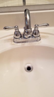 Yeni kurulmuş lavabo musluğu, iki kollu parlak gümüş, kıvrımlı olta. Yüksek kalite fotoğraf