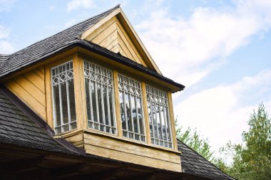 Geleneksel jöleli tavan arası ve fayansları olan eski bir evin parçası. Süslü beyaz çerçeveli ahşap sarı balkon.