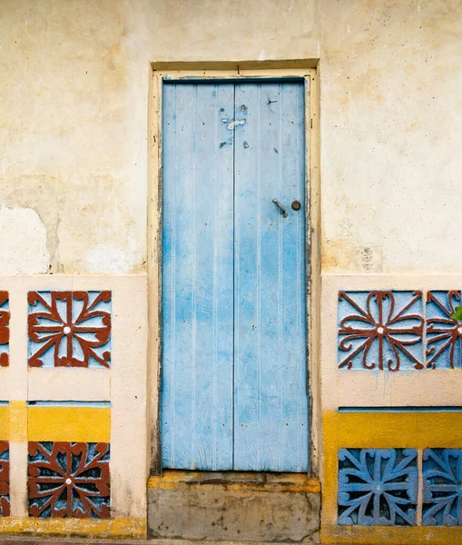 An old wooden door and a colorful decorated wall