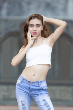 Bu modaya uygun görüntü, kendine güvenen şık bir kişinin görüntüsünü yansıtıyor. Kıyafet, göz alıcı beyaz bir hasat bluzundan oluşuyor..