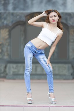 Kıyafet, açık mavi kotla eşleştirilmiş şık beyaz bir ekinden oluşuyor. Bu kotun kenarları göz kamaştırıcı detaylarla dolu..