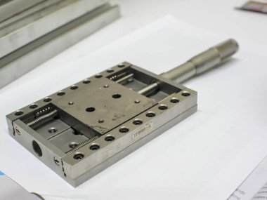 Hafifçe bulanık alüminyum mekanik bir parça, delikler, dişliler, tekerlekler. Mühendislik veya mekanik arkaplan.