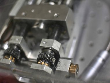 Hafifçe bulanık alüminyum mekanik bir parça, delikler, dişliler, tekerlekler. Mühendislik veya mekanik arkaplan.