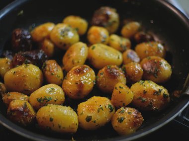 Small potatoes with aromatic herbs, cooked with butter in a pan