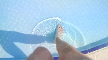 Beyaz bir adamın bacakları, açık havuza giriyor.