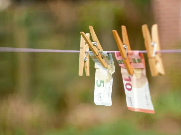 欧元钞票挂在晾衣绳上 带着衣针 背景模糊不清 受污染的资金概念或洗钱 — 图库照片