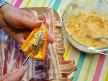 Tatlı biber hazırlığı: Peynir ve sopasco baharatıyla doldurulmuş mini sarı biberler, sonra da füme pastırmaya sarılmış..