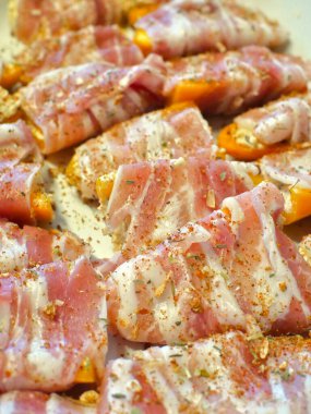 Tatlı biber hazırlığı: Peynir ve sopasco baharatıyla doldurulmuş mini sarı biberler, sonra da füme pastırmaya sarılmış..