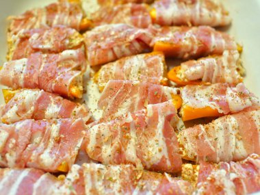 Tatlı biber hazırlığı: Peynir ve sopasco baharatıyla doldurulmuş mini sarı biberler, sonra da füme pastırmaya sarılmış..