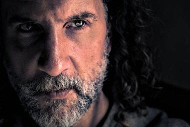 Siyah beyaz sakallı, uzun saçlı beyaz bir beyaz adamın yakın portresi. Onun parlak gözleri var ve uzaklara bakıyor. Boşluğu sağda kopyala.