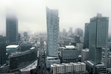 Varşova, Polonya - 118 2023: Varşova Kültür ve Bilim Sarayı 'nın tepesine bakın. Gökdelenler ve kasaba yoğun bir sis altında..