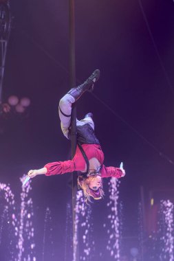 Korsan gibi giyinmiş bir sanatçı sirkte bir striptiz kulübünde akrobatik bir figür sergiliyor..