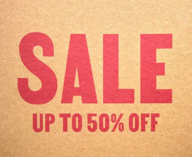 İndirim, kırmızı harflerle% 50 'ye kadar indirimli, karton desenli arka planda..