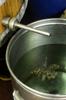 Alembik bir çıkış borusundan alkol akıyor.