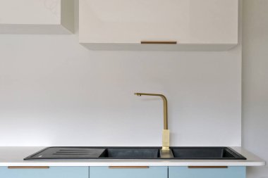 Siyah granit lavaboda pirinç karıştırıcı musluğu.