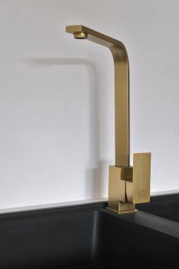 Siyah granit lavaboda pirinç karıştırıcı musluğu.