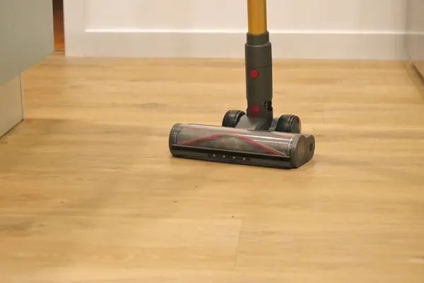 Rotative brush of a vacuum cleaner,  on pvc parquet, imitation wood.