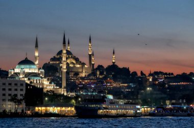 İstanbul, Türkiye - 05: 07 2024: Yeni Cami ve Süleyman Camii ile Eminonu ilçesinin gece manzarası.