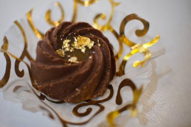 Küçük oryantal pasta, altın yaprak ile süslenmiş mermer beyaz arka plan.